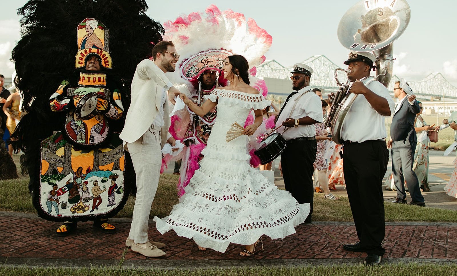 Brunette bride wearing Grace Loves Lace Coco Gown dancing with groom in parade