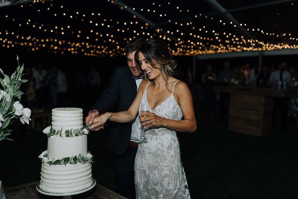 Bride wearing Grace Loves Lace Rosa Gown cutting cake with groom
