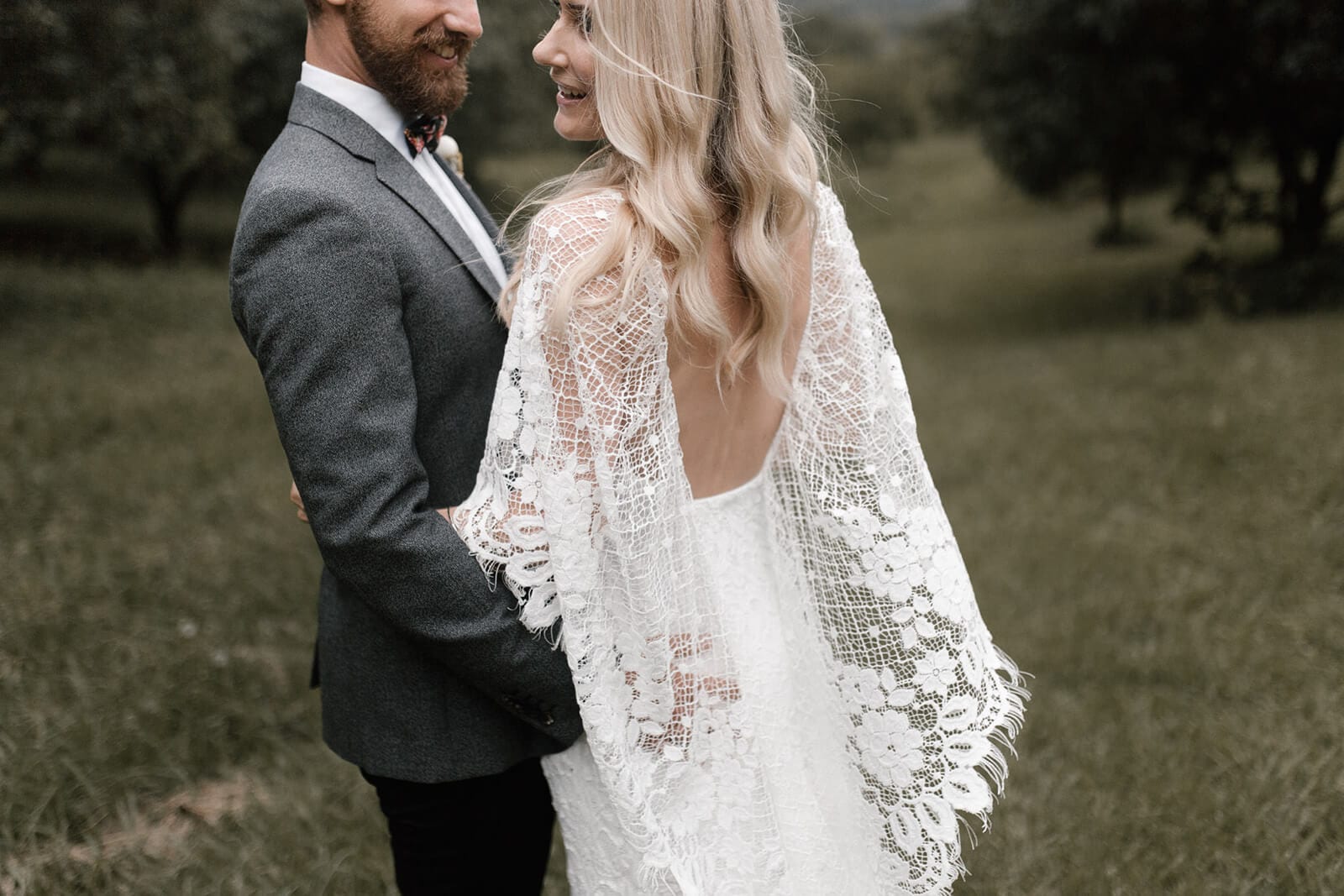 Back shot of bride wearing Grace Loves Lace Verdelle 2.0 Gown being held by groom
