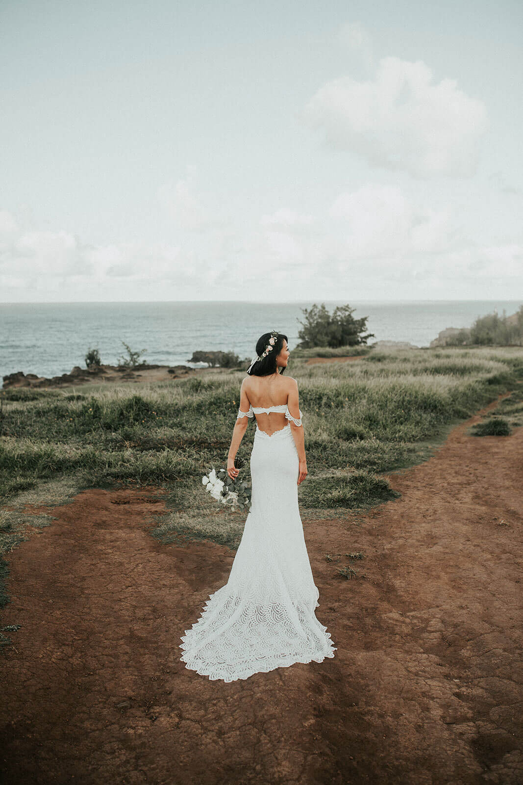 Back shot of bride wearing Grace Loves Lace Paloma Gown holding bouquet
