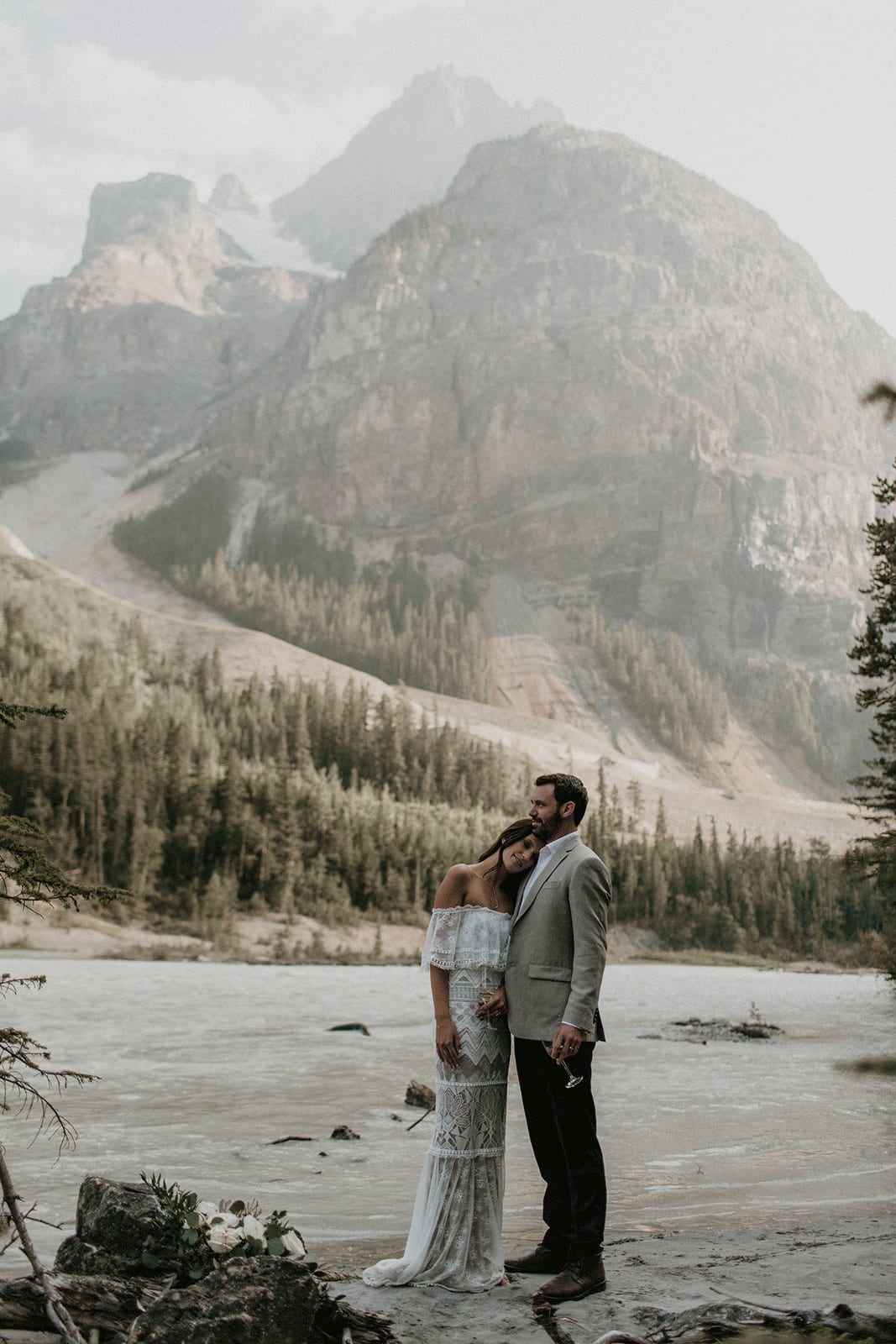 Brunette bride wearing Grace Loves Lace Emanuela Gown leaning on groom's shoulder