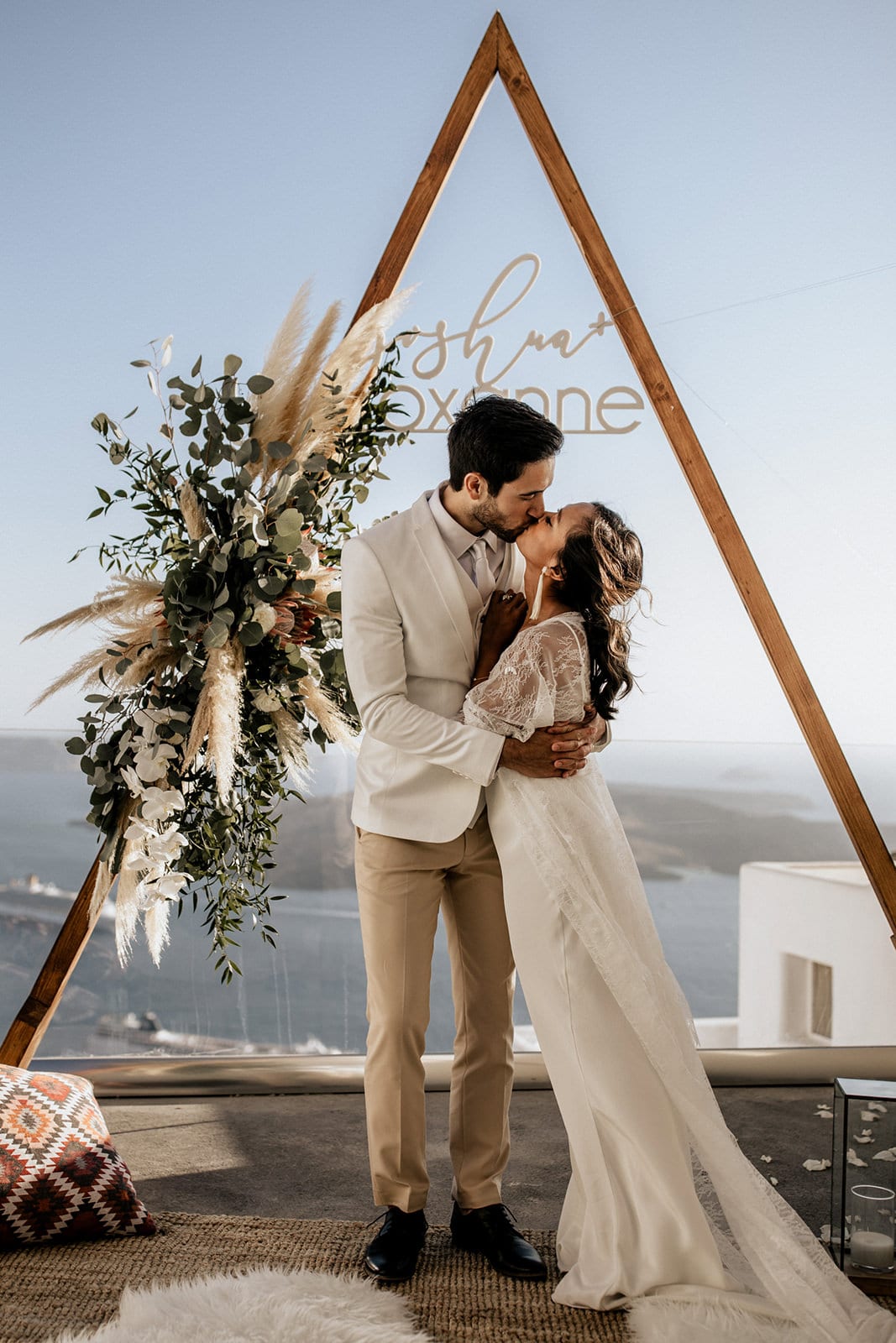 Brunette bride wearing Grace Loves Lace Arlo Gown kissing groom