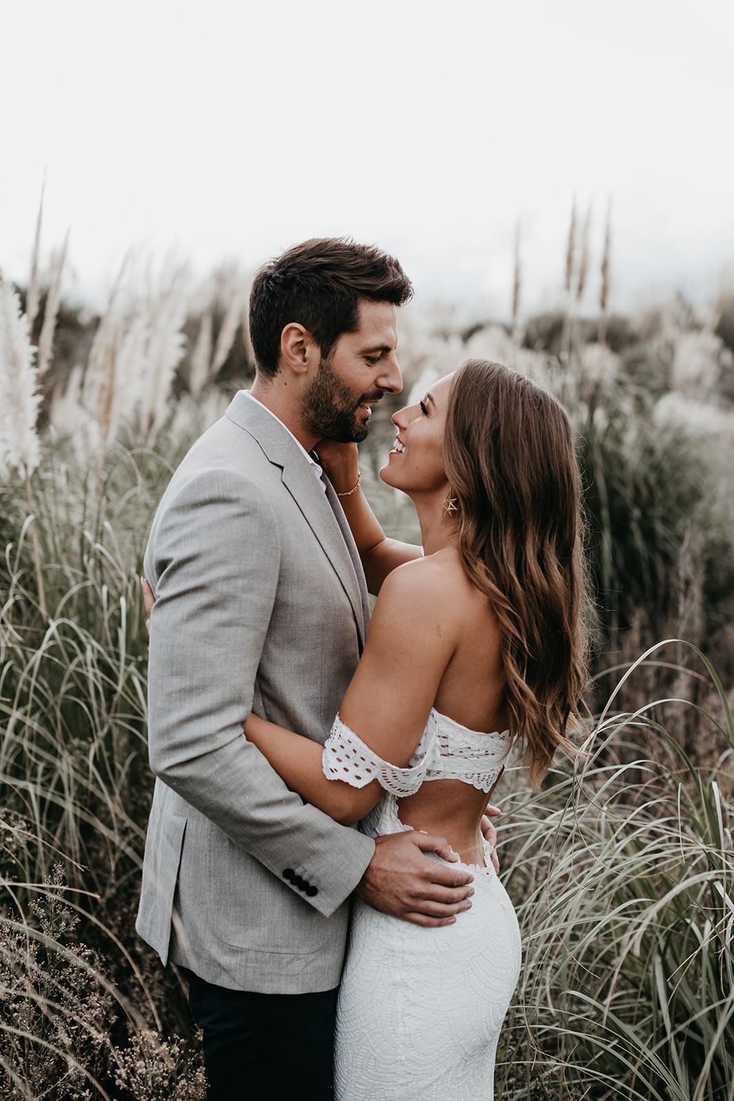 Blonde bride wearing Grace Loves Lace Paloma Gown embracing groom