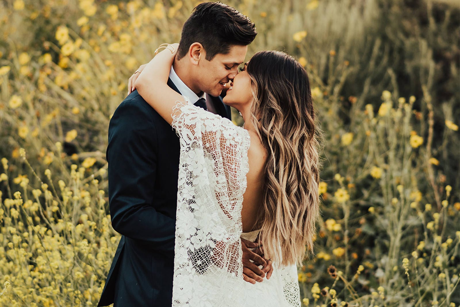 Bride wearing Grace Loves Lace Verdelle 2.0 Gown kissing groom