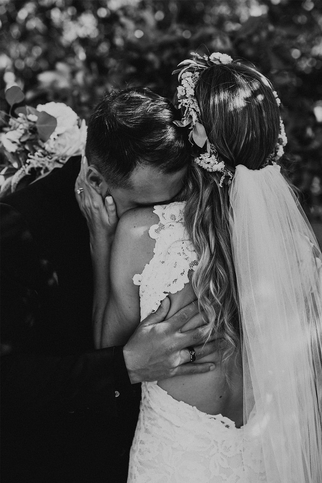 Black and white shot of bride wearing Grace Loves Lace Alexandra Gown with groom leaning on shoulder