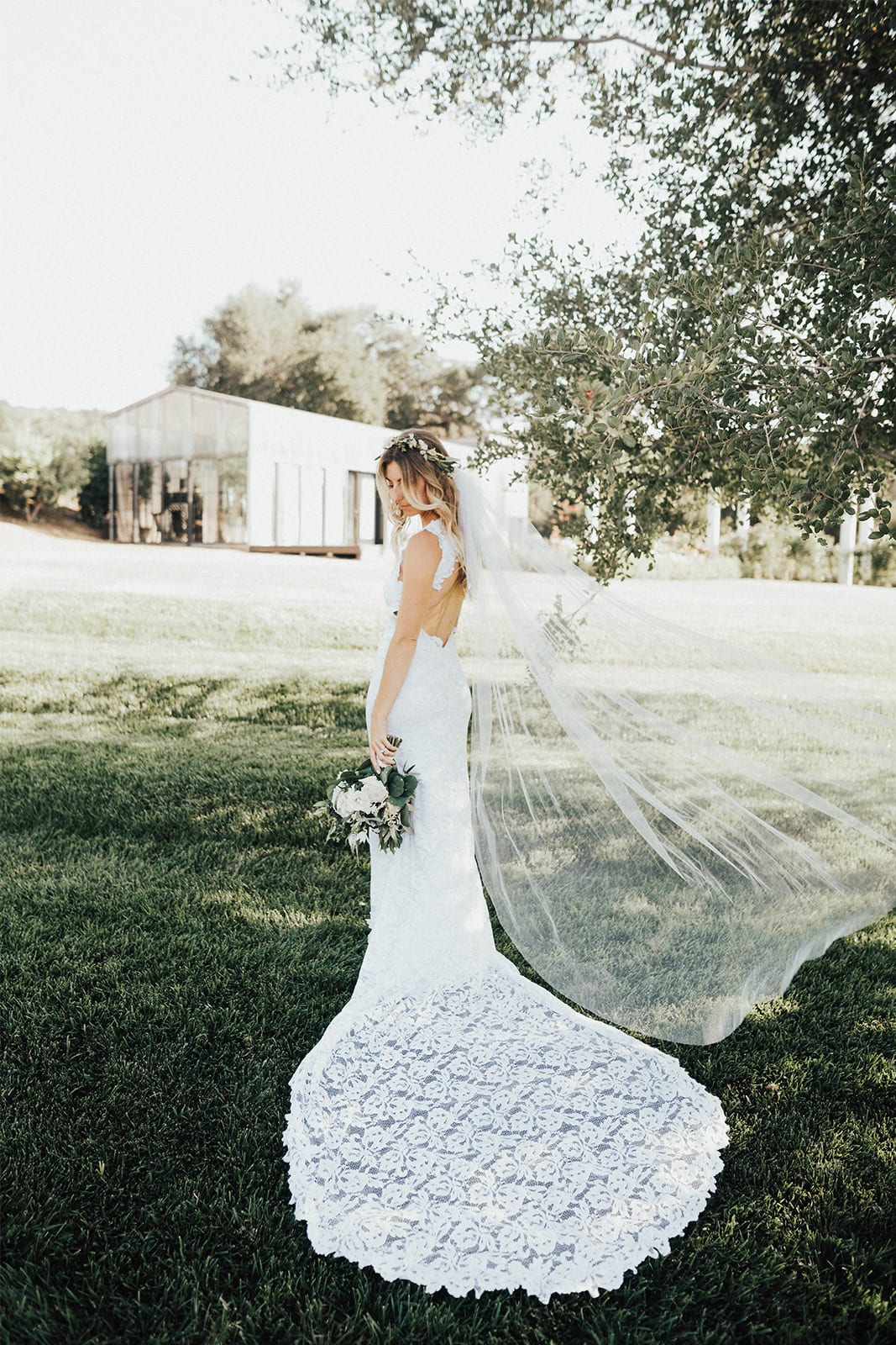 Back shot of bride wearing Grace Loves Lace Alexandra Gown holding bouquet