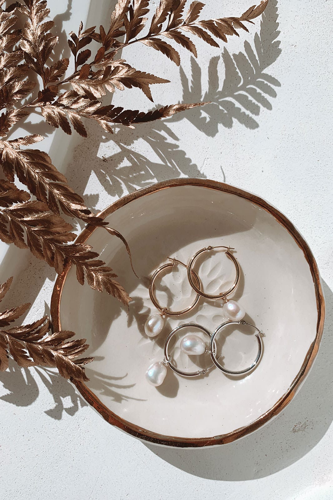 Grace Loves Lace Sade Earrings in white dish with rose gold leaves